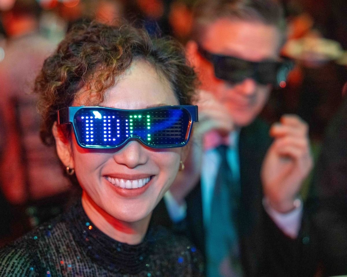Smiling guest wearing LED party glasses at the gala dinner