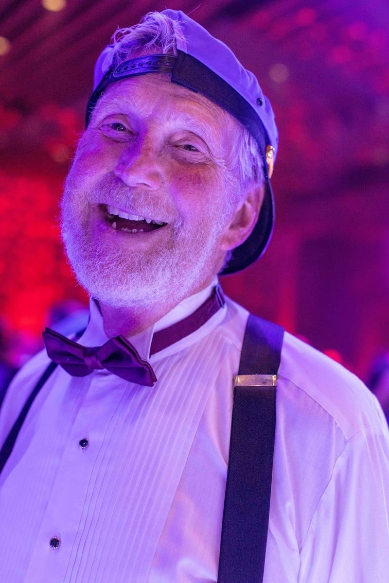 Laughing guest in a captain's hat and bow tie on the dance floor