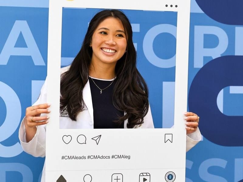 Attendee posing with a California Medical Association social media photo frame — corporate event photography by Michael Pegram