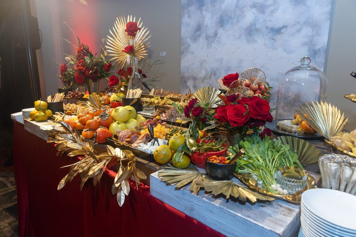 Lavish grazing table with fruit, red roses and gold accents at a Farallon Capital holiday party in San Francisco — corporate event photography by Michael Pegram