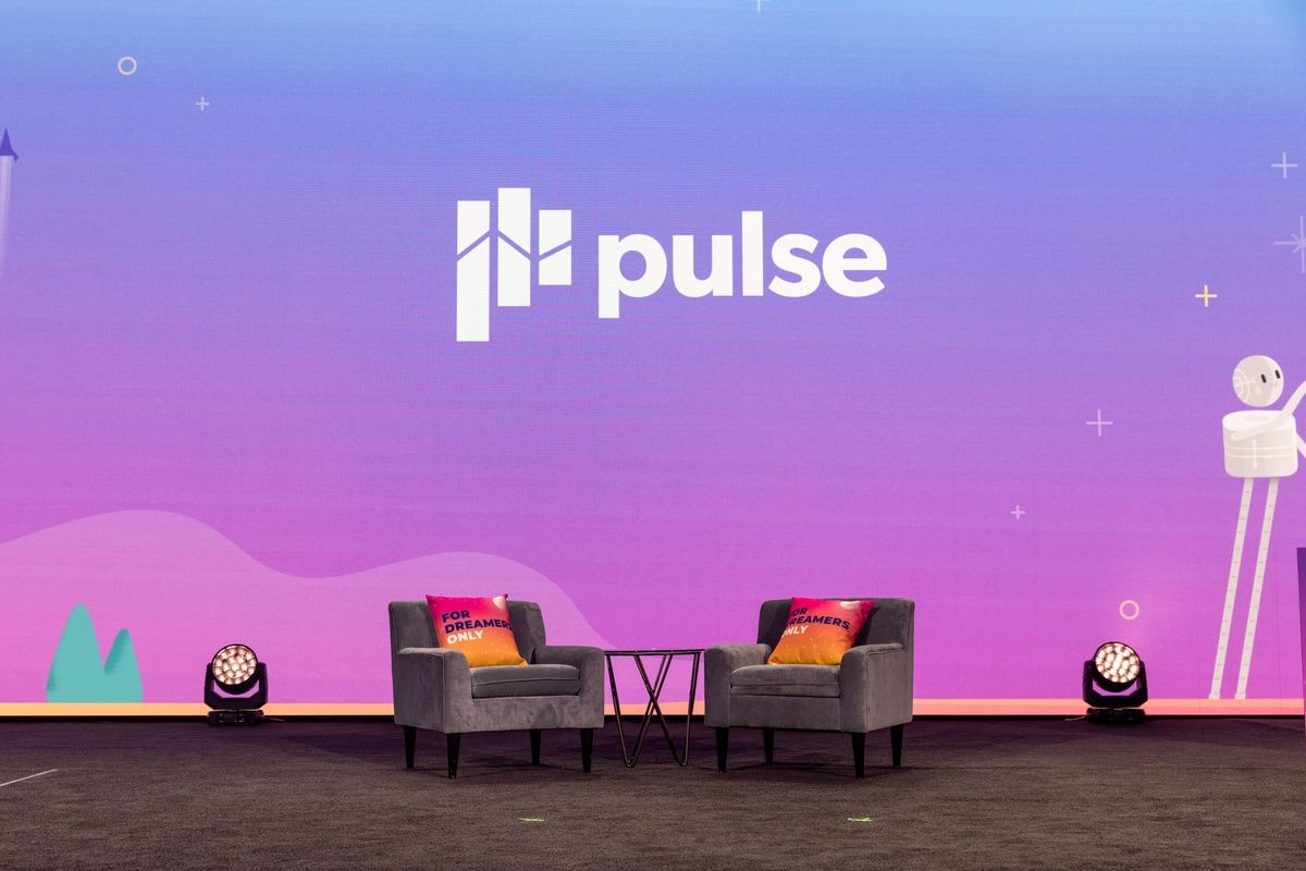 Pulse main stage set with two lounge chairs before the keynote at Gainsight Pulse, Moscone West, San Francisco — corporate event photography by Michael Pegram