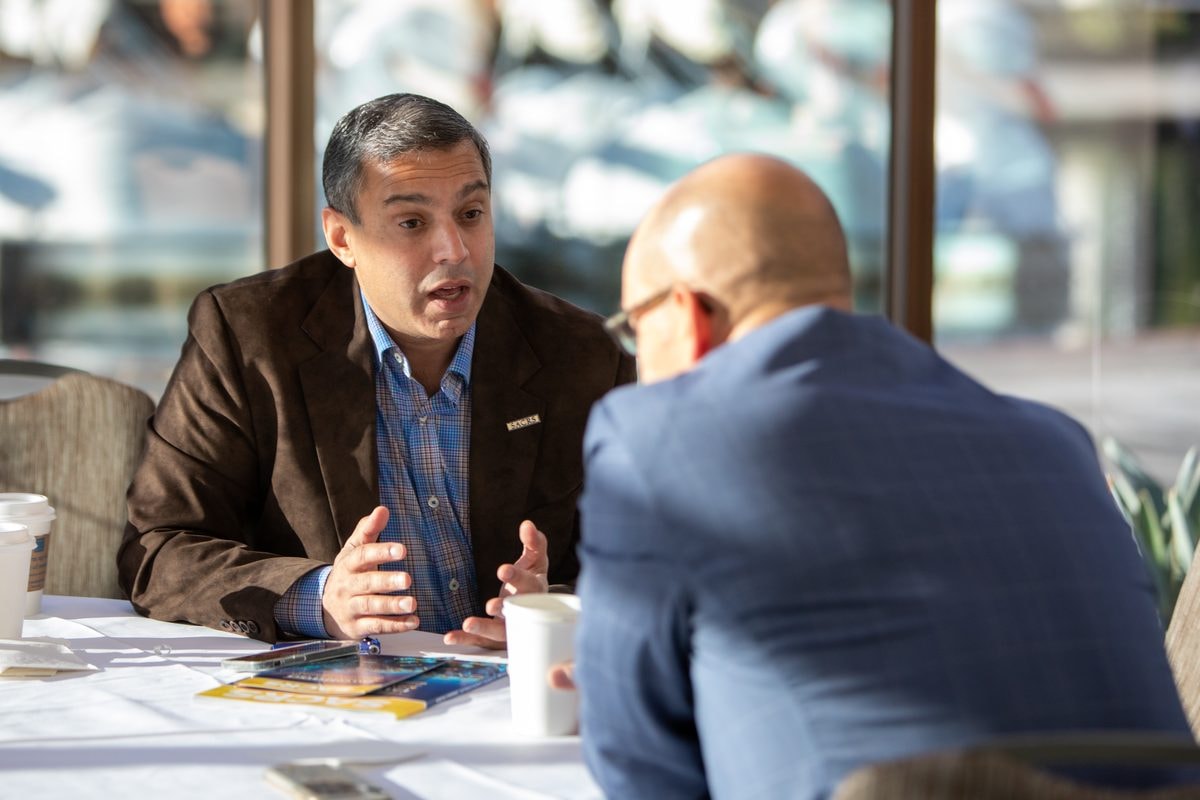 Two attendees in a one-on-one conversation at the SACRS conference — corporate event photography by Michael Pegram