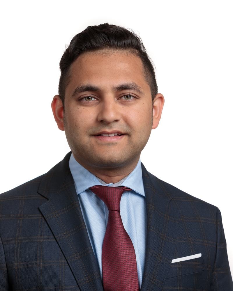 Corporate headshot of a smiling executive in a navy suit and red tie on a white backdrop — San Francisco headshot by Michael Pegram
