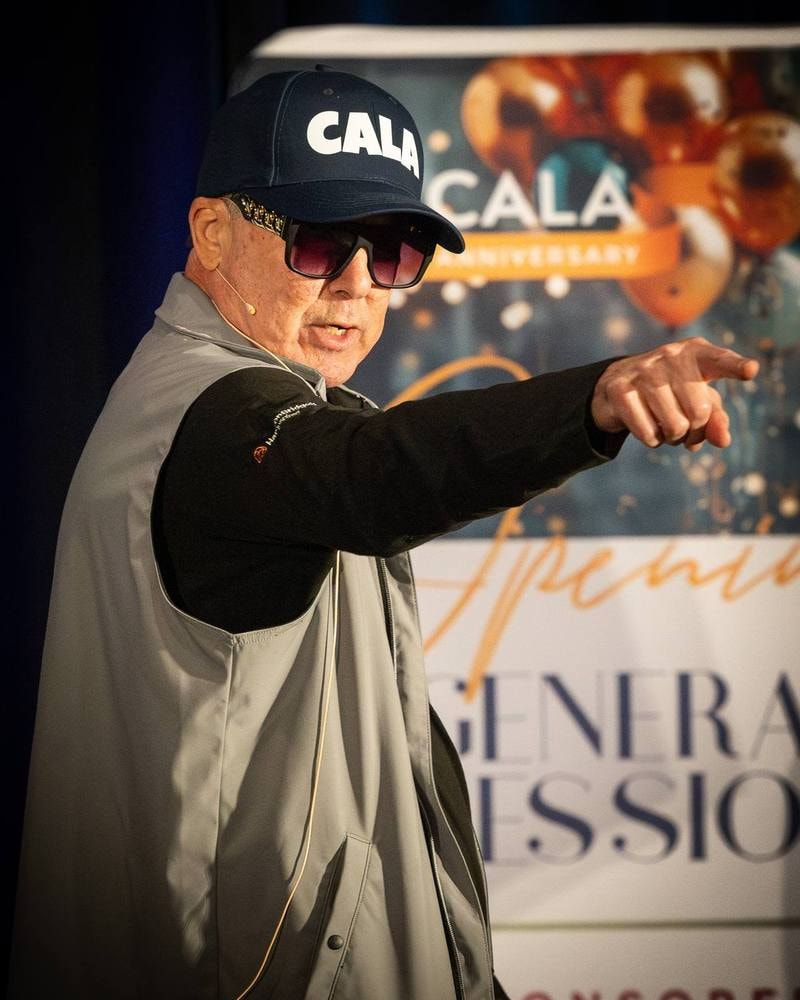 Energetic speaker pointing to the crowd during a CALA general session — event photography by Michael Pegram