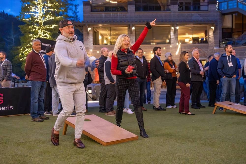Attendees playing cornhole at an evening team event — event photography by Michael Pegram
